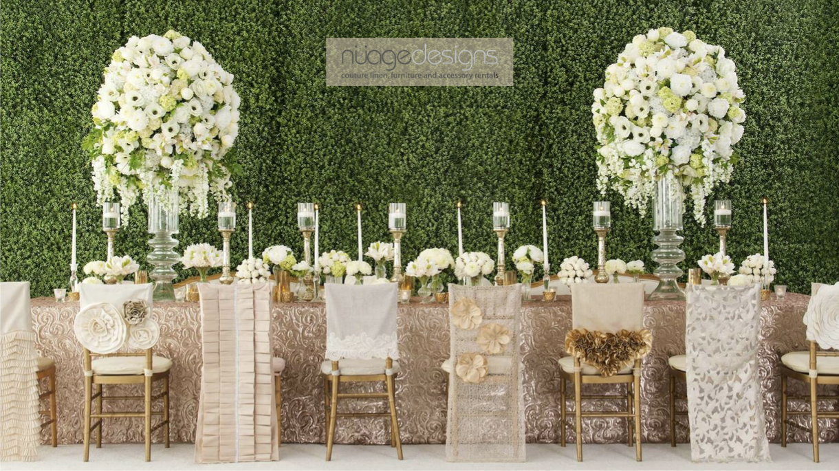 An inspirational wedding table and lounge set up in wood and cream tones with a variety of chairs and furniture and a hanging driftwood accent.